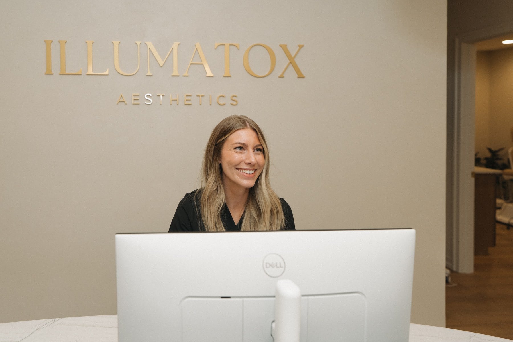 A team member working at the front desk of Illumatox Aesthetic Studio in Neenah