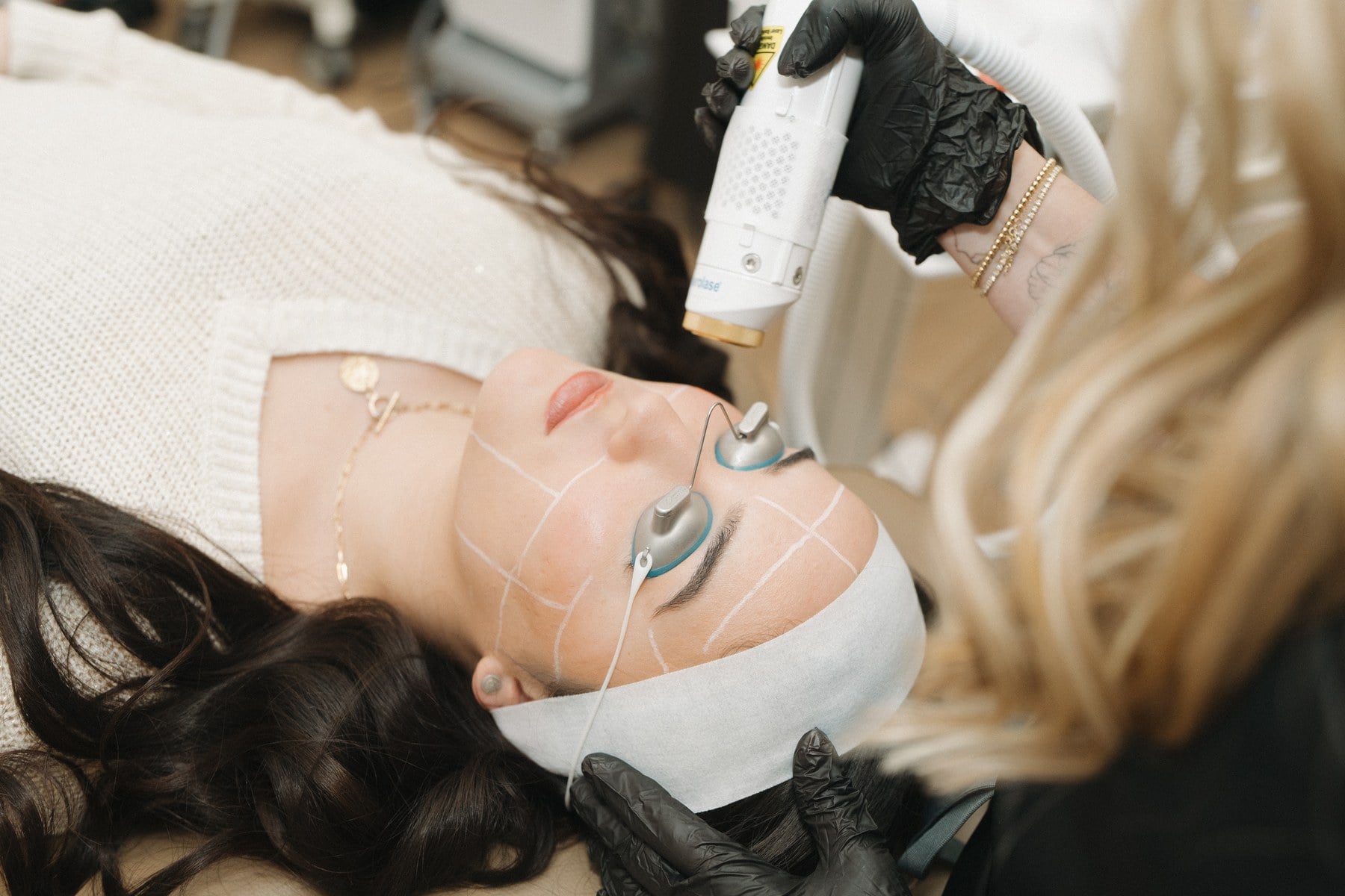 An esthetician working across a client's face during a facial at Illumatox in Neenah