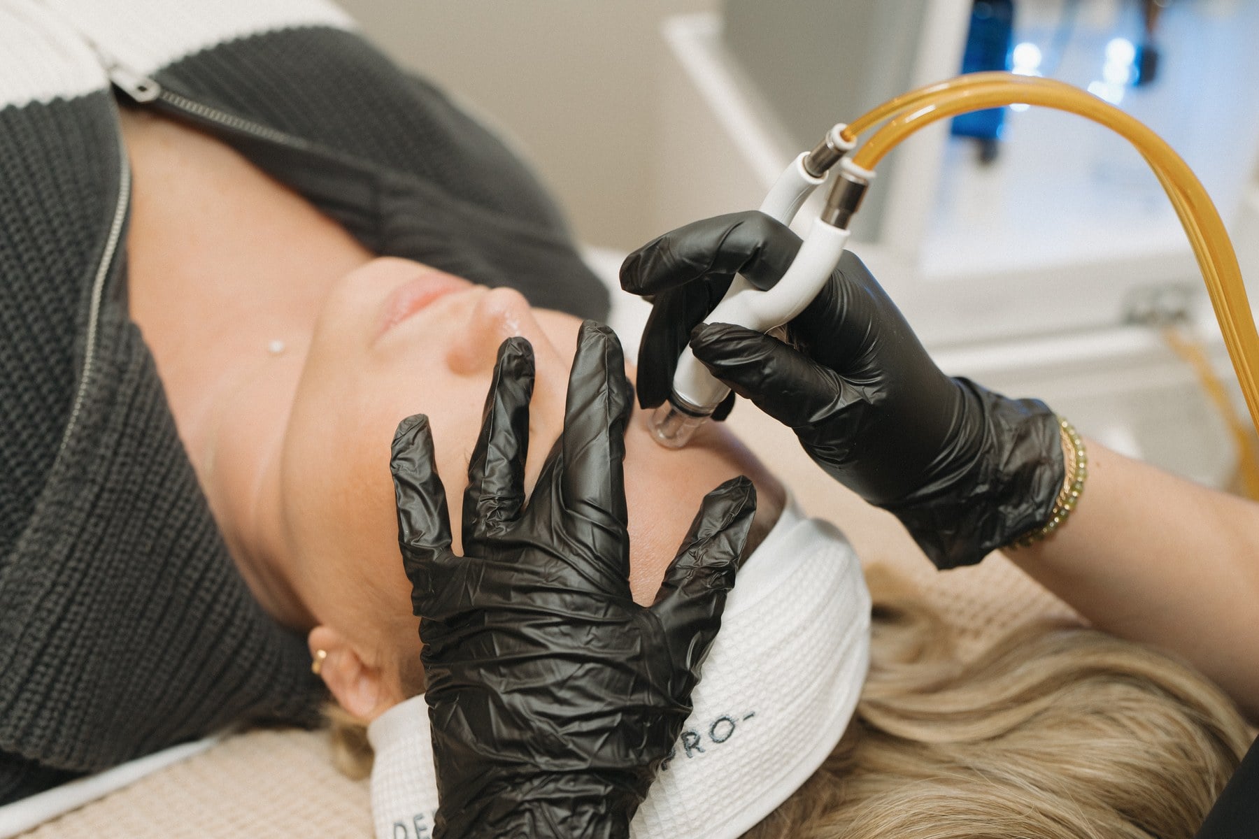 An oxygenating facial handpiece being used on a reclined client at Illumatox in Neenah