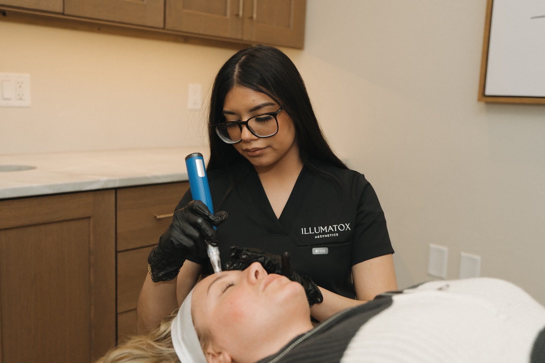 A treatment handpiece positioned over a client's face during a skin appointment at Illumatox in Neenah