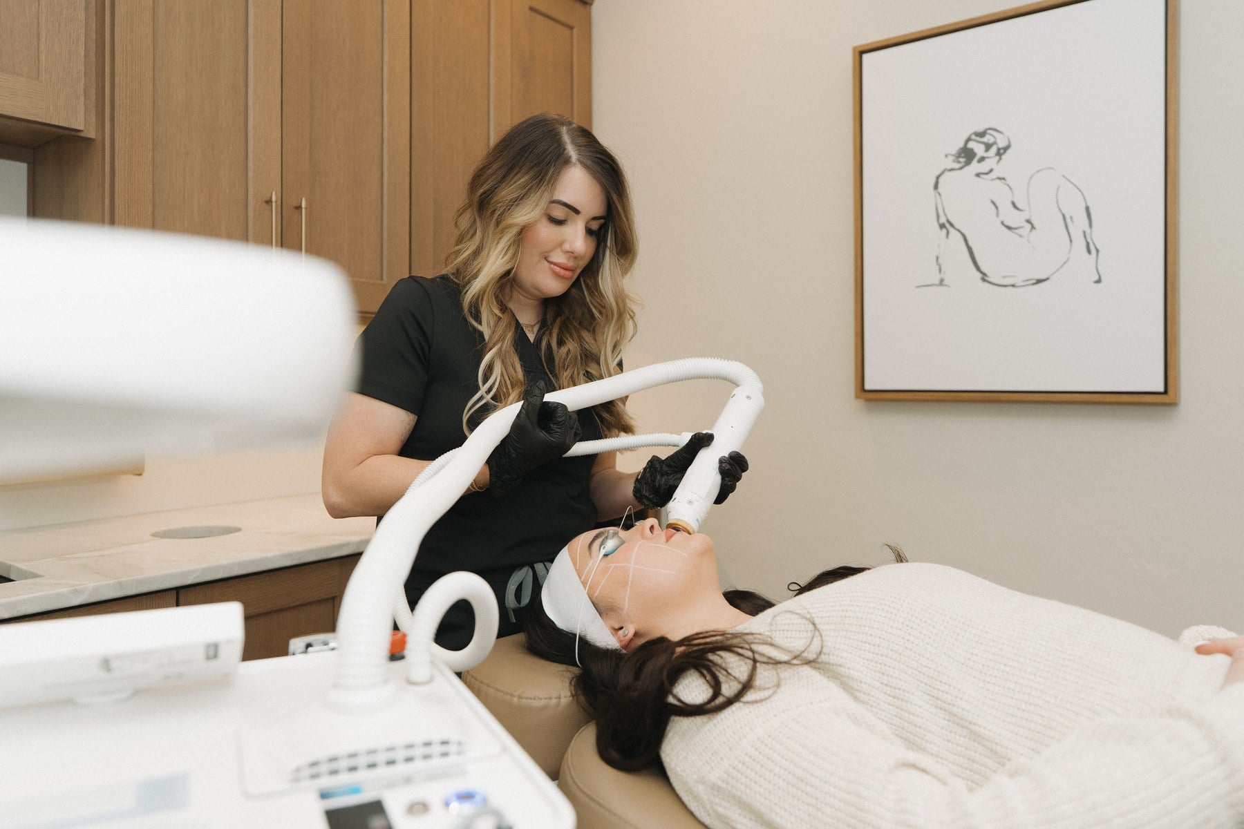 An LED canopy positioned over a client during a facial at Illumatox in Neenah