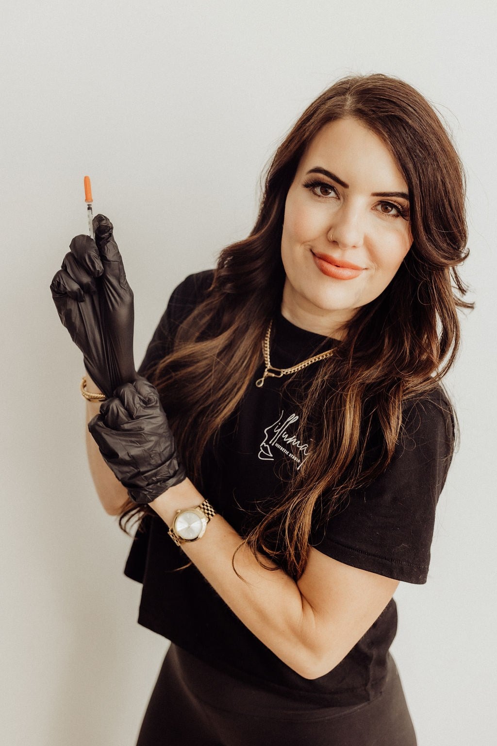 A nurse practitioner holding a prepared syringe at Illumatox Aesthetic Studio in Neenah